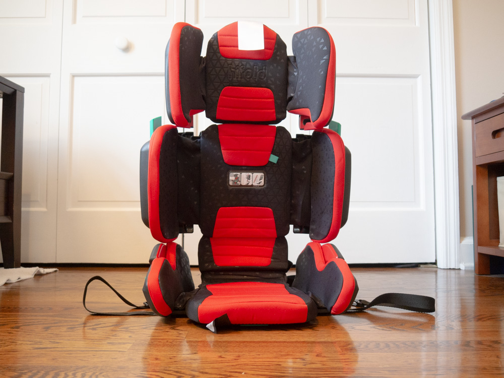 Travel Car Seat Expert - A red and black travel car seat on a wood floor.