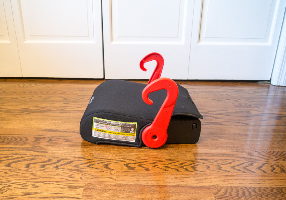 Side view of black Graco Turbo GO booster seat unfolded, with red belt guides sticking up