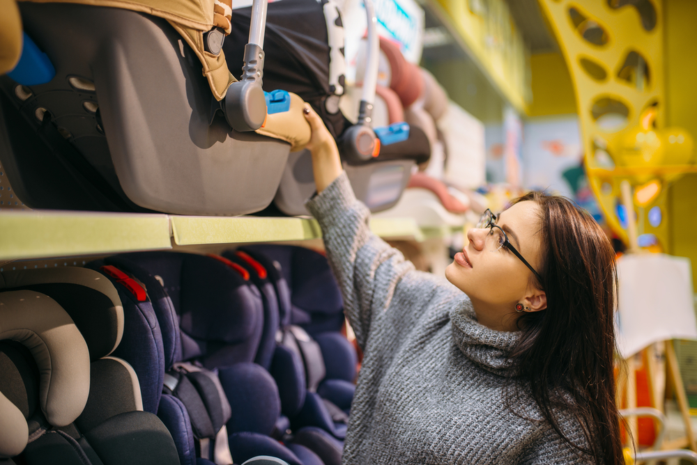 woman reaching to look at best cheap car seats under $100