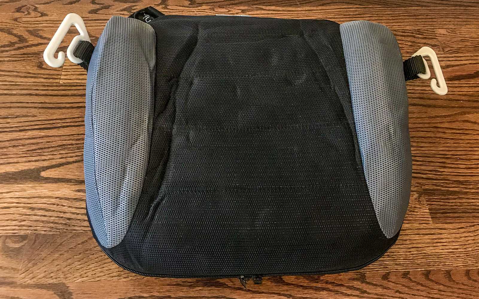 Travel Car Seat Expert - A black and grey cushion on a wood surface, perfect for flying with a car seat.