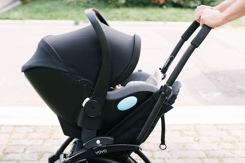 Clek liing car seat on a Babyzen Yoyo stroller, two hands pushing stroller