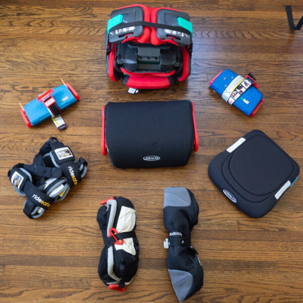 Travel Car Seat Expert - A group of objects on a wood floor, including a travel car seat.