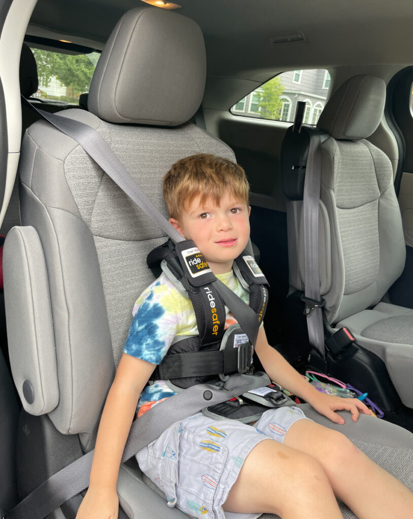 Travel Car Seat Expert - A young boy sitting in the back seat of a car.