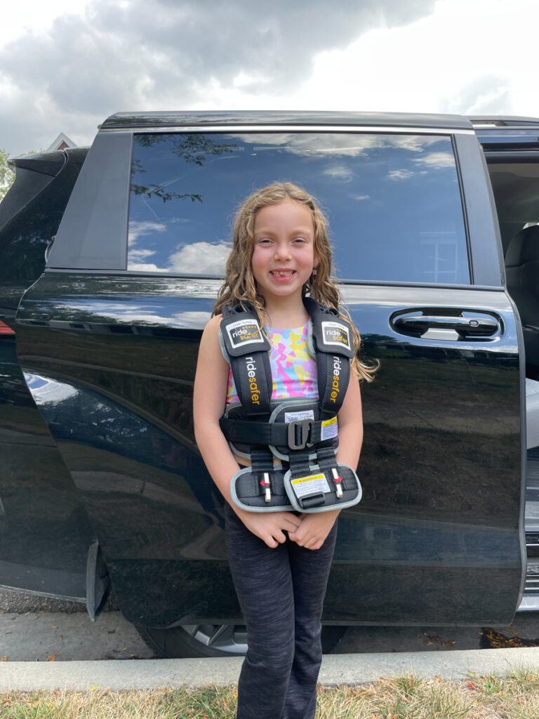 Travel Car Seat Expert - A young girl standing in front of a black suv.