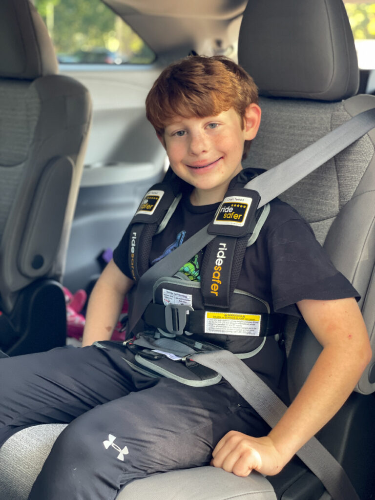 Travel Car Seat Expert - A young boy sitting in the back seat of a car.