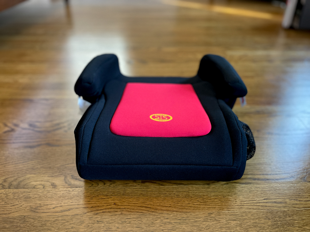 Travel Car Seat Expert - A black and red car seat on a wooden floor.