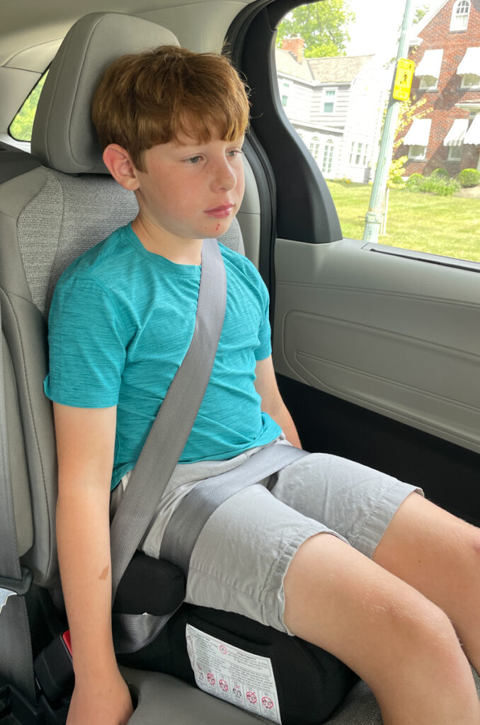 Travel Car Seat Expert - A young boy sitting in the back seat of a car.