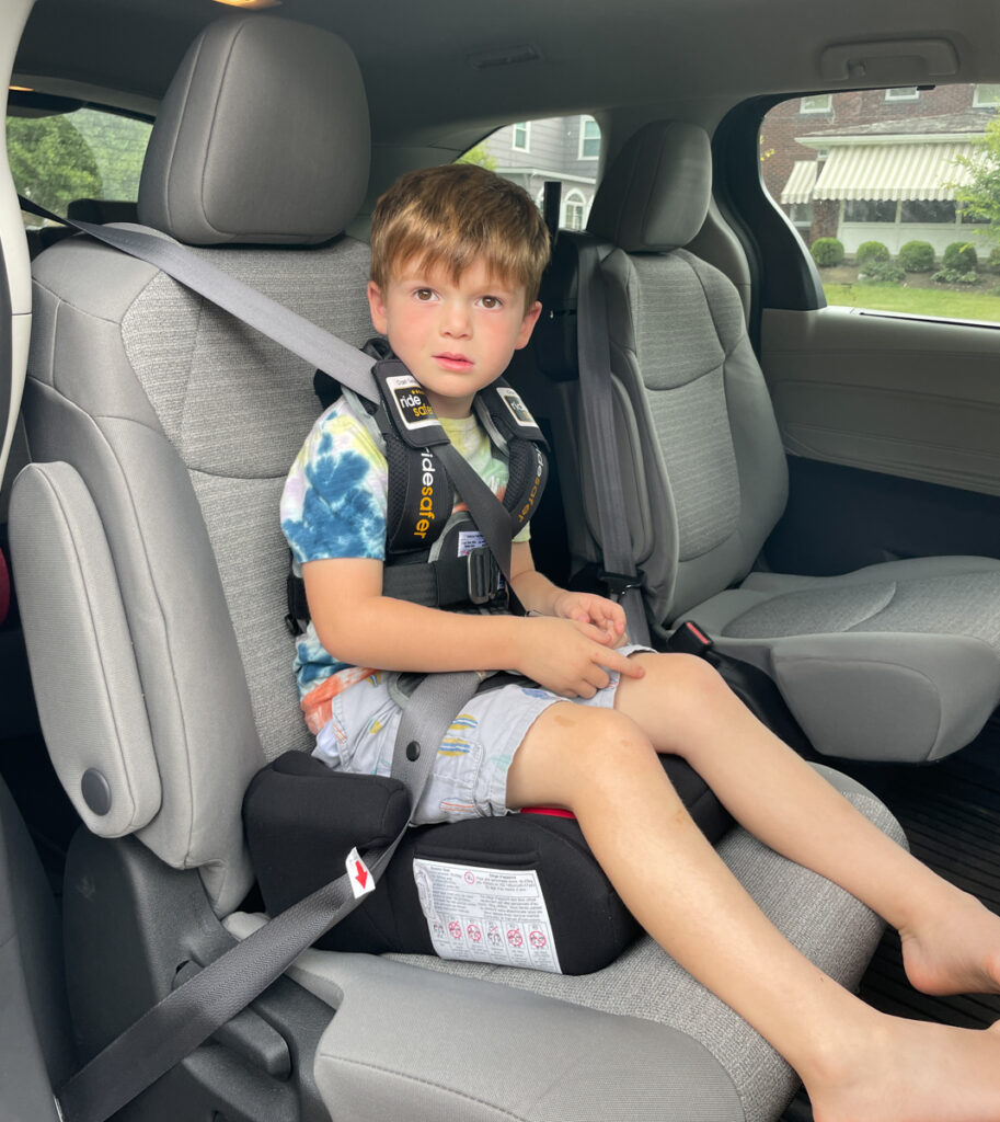 Travel Car Seat Expert - A young boy sitting in the back seat of a car.