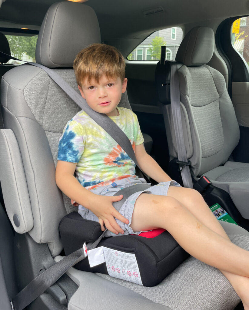 Travel Car Seat Expert - A young boy sitting in the back seat of a car.