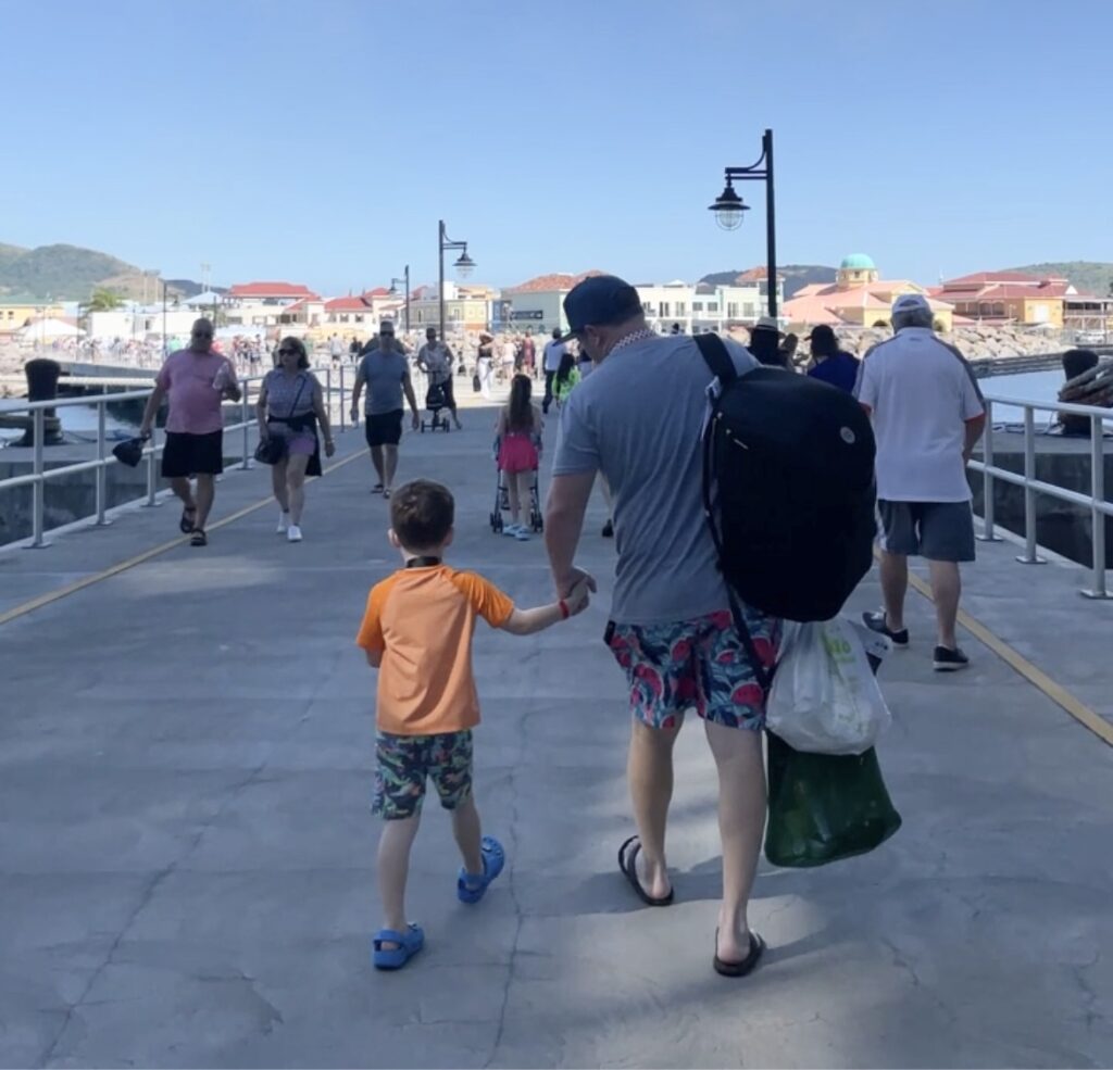 Travel Car Seat Expert - Wayb Pico review: An expert and traveling parents weigh in on a man and a child walking down a pier.