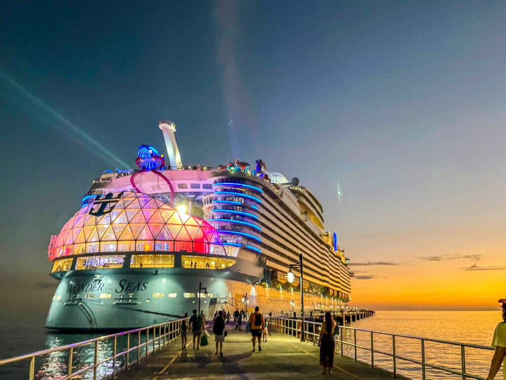 Travel Car Seat Expert - As the sun sets, casting a warm glow over the pier, a large cruise ship adorned with colorful lights welcomes passengers. Consider cruising into the twilight as people eagerly walk towards their next adventure aboard the magnificent vessel.