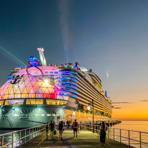 Travel Car Seat Expert - As the sun sets, casting a warm glow over the pier, a large cruise ship adorned with colorful lights welcomes passengers. Consider cruising into the twilight as people eagerly walk towards their next adventure aboard the magnificent vessel.